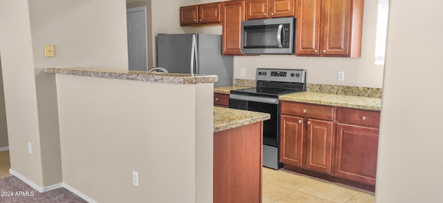 kitchen featuring light stone countertops, appliances with stainless steel finishes, and light tile patterned flooring