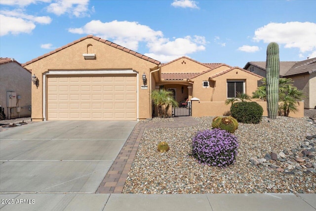 mediterranean / spanish-style home featuring a garage, concrete driveway, a tile roof, fence, and stucco siding