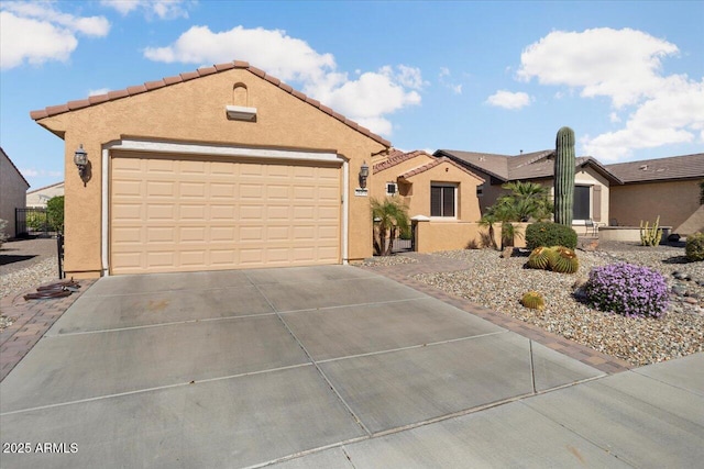 mediterranean / spanish-style home with a garage, a tiled roof, and stucco siding