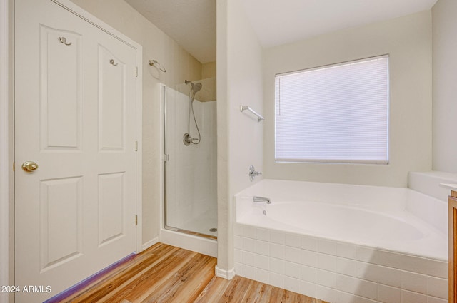 bathroom with hardwood / wood-style floors and plus walk in shower