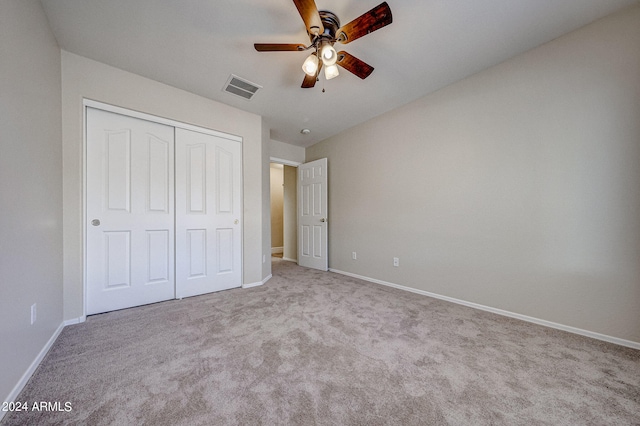 unfurnished bedroom with ceiling fan, light colored carpet, and a closet