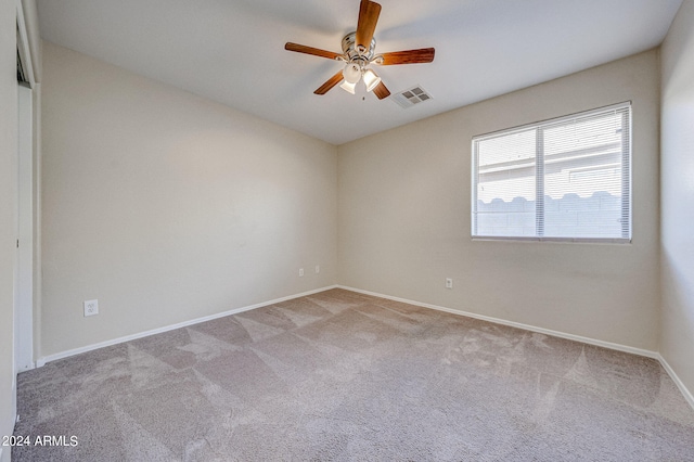 spare room featuring light carpet and ceiling fan