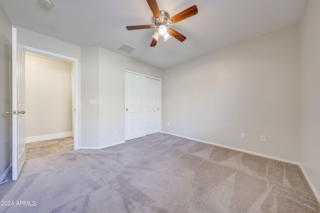 unfurnished bedroom with carpet floors, a closet, and ceiling fan