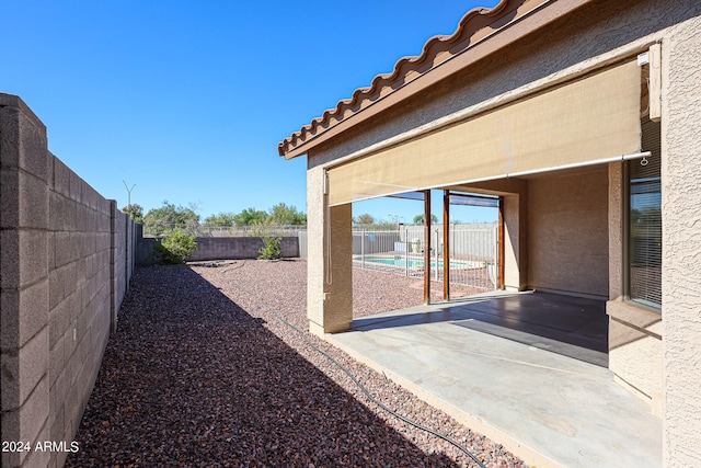 view of yard with a fenced in pool and a patio