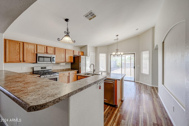 kitchen featuring sink, hanging light fixtures, a center island with sink, appliances with stainless steel finishes, and dark hardwood / wood-style floors