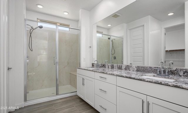 bathroom featuring vanity and a shower with shower door