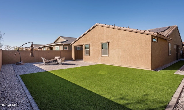 back of house featuring a patio area and a lawn