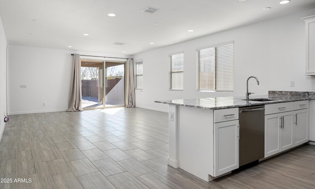 kitchen featuring dishwasher, sink, light stone countertops, and white cabinets