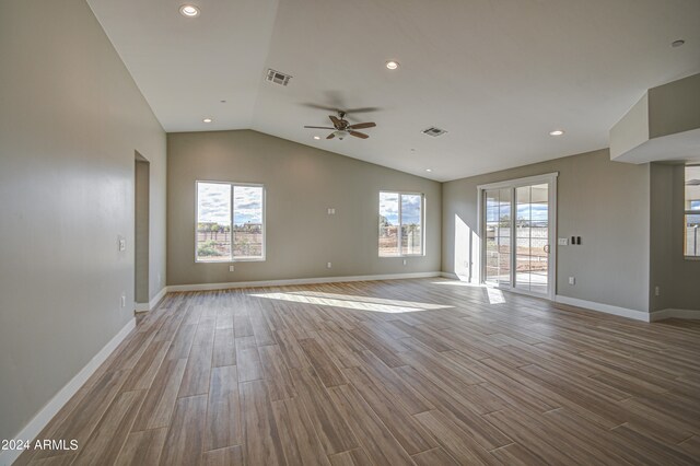 unfurnished room featuring lofted ceiling, hardwood / wood-style floors, ceiling fan, and a wealth of natural light