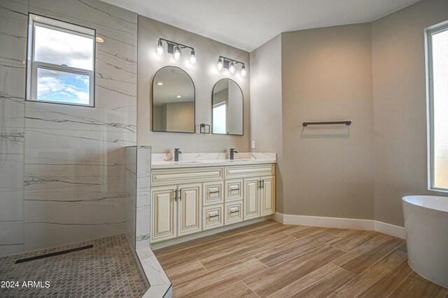 bathroom featuring double sink, oversized vanity, and a tub