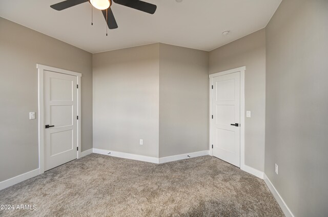 spare room featuring ceiling fan and light colored carpet