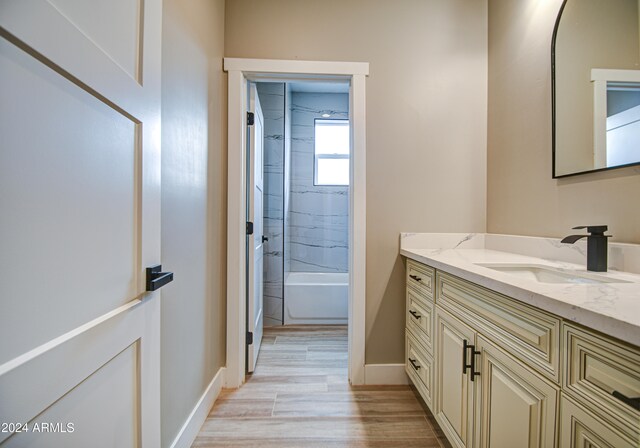 bathroom with tiled shower / bath combo and vanity