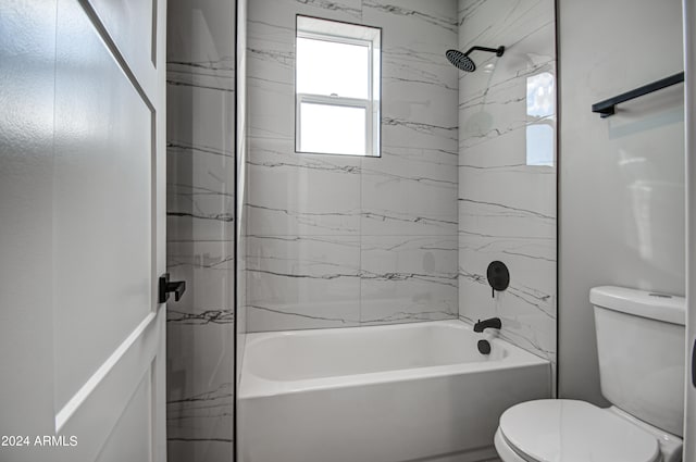 bathroom with tiled shower / bath combo and toilet