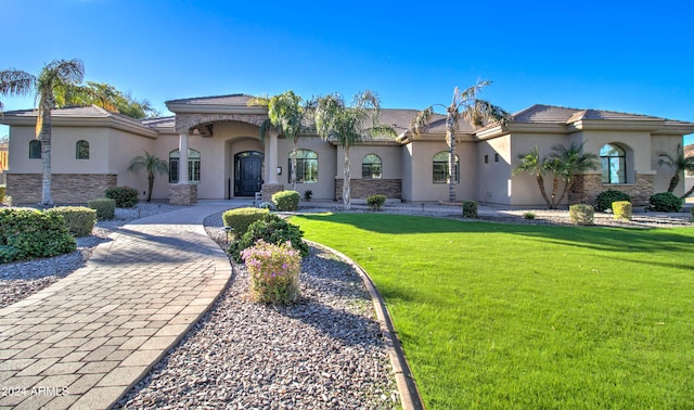 mediterranean / spanish-style home with a front yard