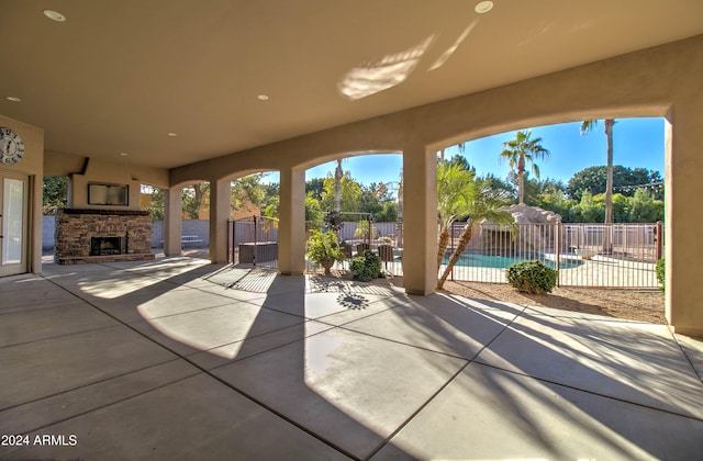 view of patio featuring a community pool and an outdoor stone fireplace