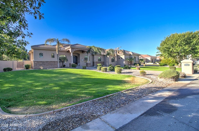 mediterranean / spanish home with a front yard