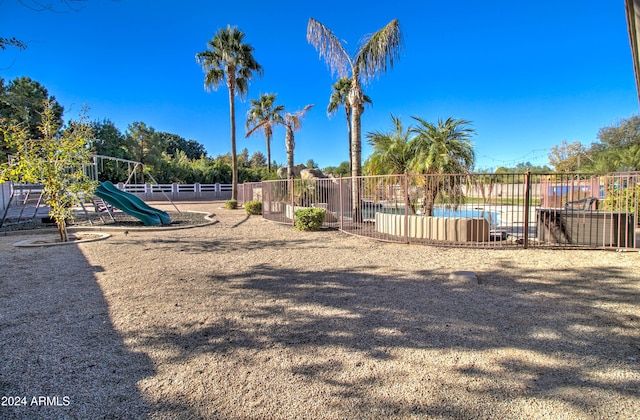 view of playground with a fenced in pool