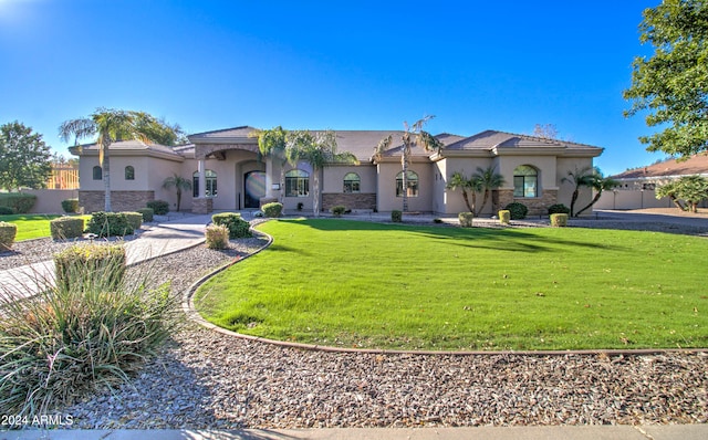 mediterranean / spanish-style home with a front yard