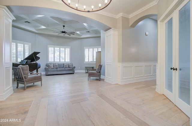 sitting room featuring light wood-type flooring, crown molding, and coffered ceiling