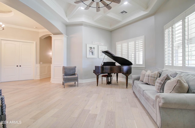 living area with a wealth of natural light, light hardwood / wood-style floors, crown molding, and coffered ceiling