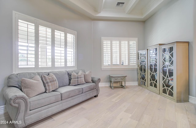 living room with wood-type flooring, a healthy amount of sunlight, and crown molding