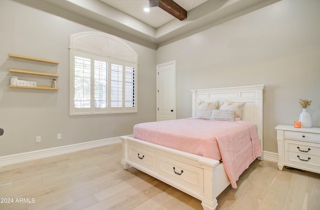 bedroom featuring beam ceiling and light hardwood / wood-style flooring