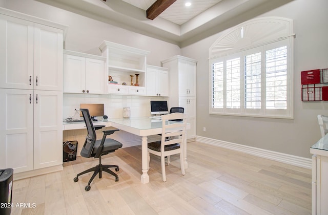 office area featuring light wood-type flooring, built in desk, and beam ceiling