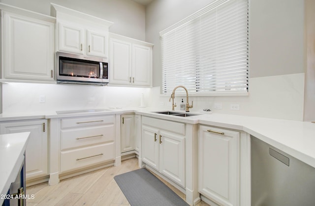 kitchen with sink, light hardwood / wood-style floors, and white cabinets