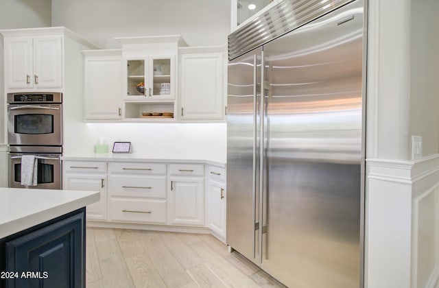 kitchen featuring white cabinetry, appliances with stainless steel finishes, and light hardwood / wood-style floors