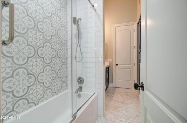 bathroom featuring tile patterned flooring, tiled shower / bath, and vanity