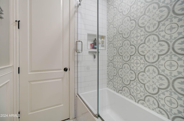 bathroom with bath / shower combo with glass door