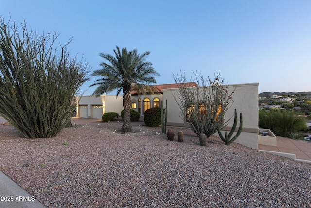 view of front of property featuring a garage, driveway, and stucco siding