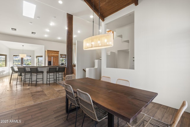 dining space with wood ceiling, beamed ceiling, wood finished floors, and visible vents