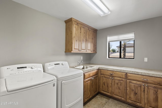 laundry room featuring cabinet space, washer and clothes dryer, and a sink