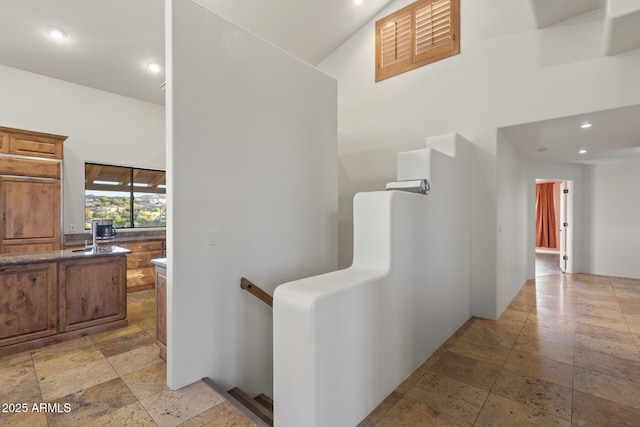 corridor with stone tile flooring and recessed lighting