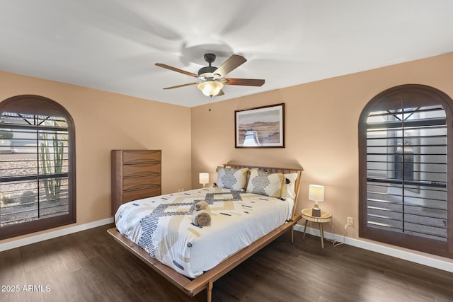 bedroom with a ceiling fan, baseboards, and wood finished floors