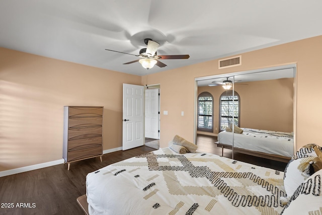 bedroom with wood finished floors, a ceiling fan, visible vents, baseboards, and a closet