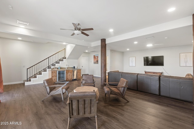 living room featuring beverage cooler, visible vents, dark wood finished floors, and stairs