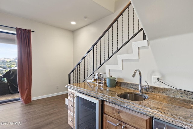 bar with wine cooler, dark wood-type flooring, a sink, baseboards, and wet bar