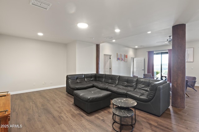 living area with baseboards, visible vents, and wood finished floors