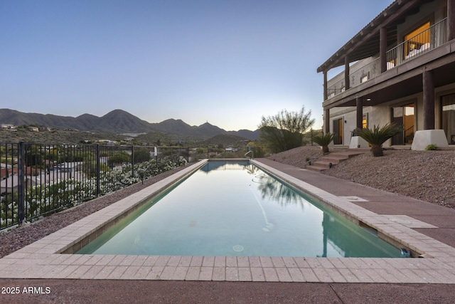 view of swimming pool featuring a patio area, fence, a mountain view, and a fenced in pool