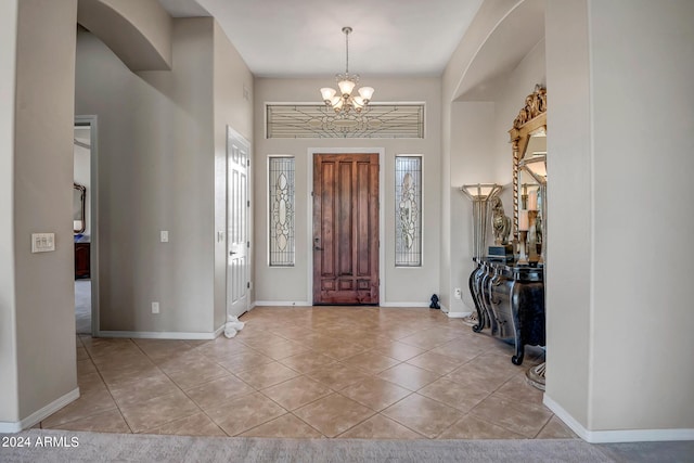 tiled foyer with a notable chandelier