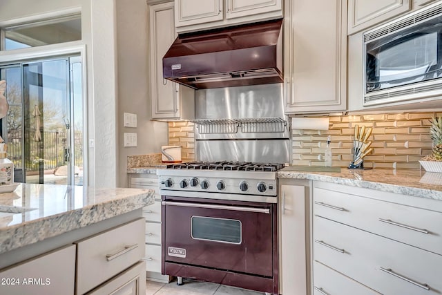 kitchen with light stone counters, appliances with stainless steel finishes, ventilation hood, and backsplash