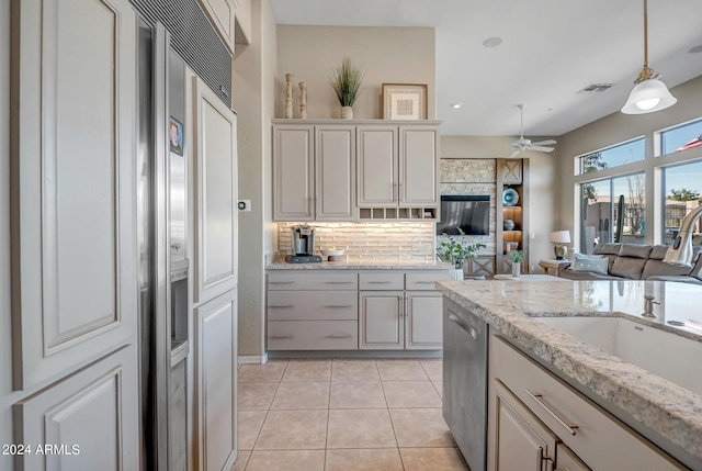 kitchen featuring sink, tasteful backsplash, decorative light fixtures, light tile patterned floors, and dishwasher