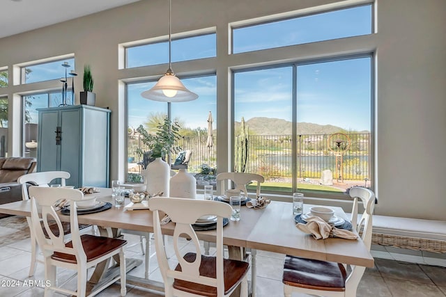 tiled dining space with a water and mountain view