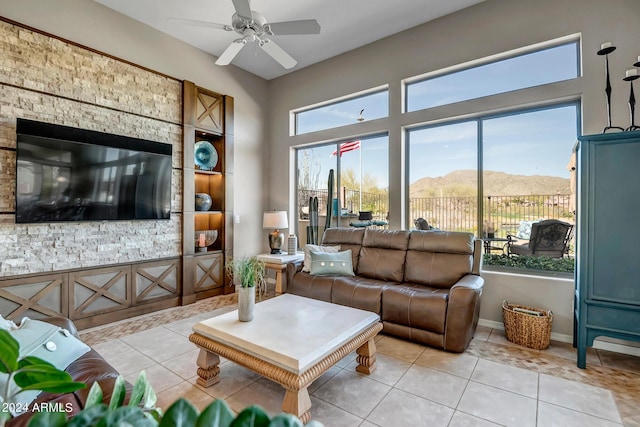 living room featuring a mountain view, light tile patterned floors, and ceiling fan