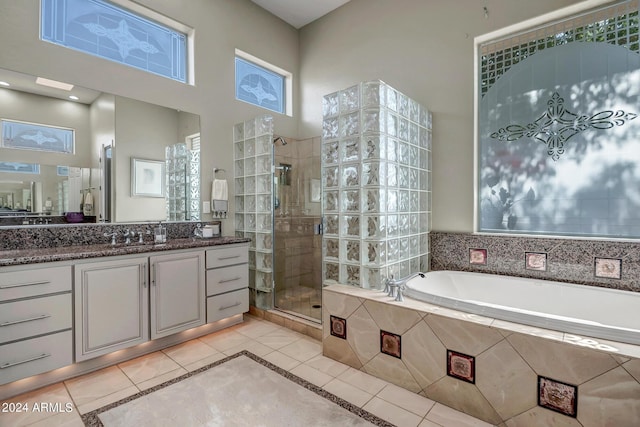 bathroom featuring tile patterned flooring, plus walk in shower, a high ceiling, and vanity