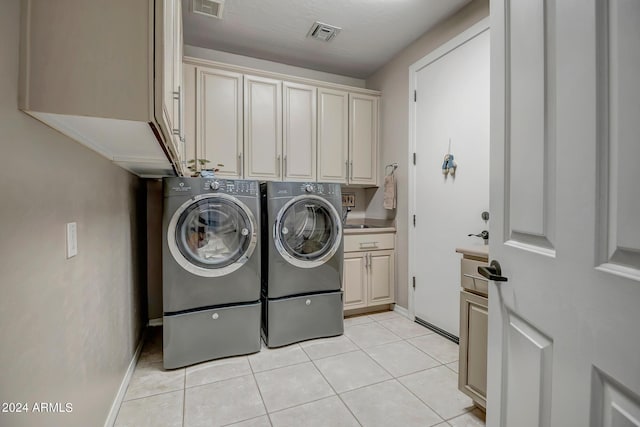 laundry area with washer and dryer, light tile patterned floors, sink, and cabinets