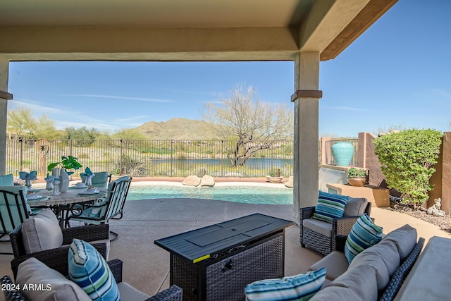 view of patio featuring outdoor lounge area, a fenced in pool, and a water and mountain view