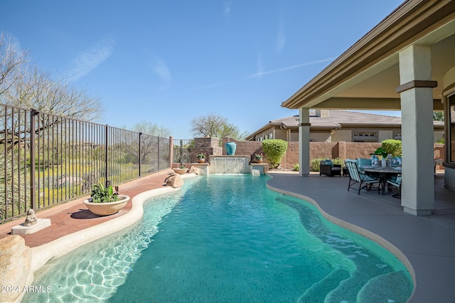 view of swimming pool featuring pool water feature and a patio